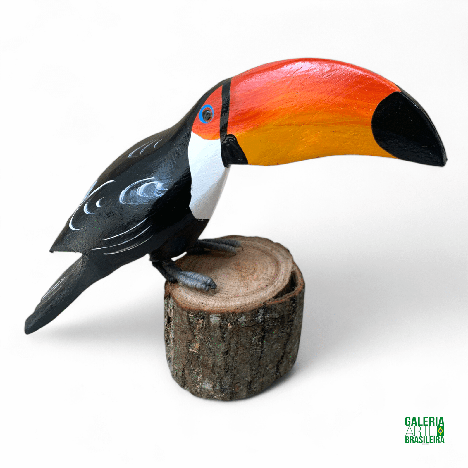 Escultura de tucano em madeira sobre tronco, com pintura colorida e acabamento artesanal.